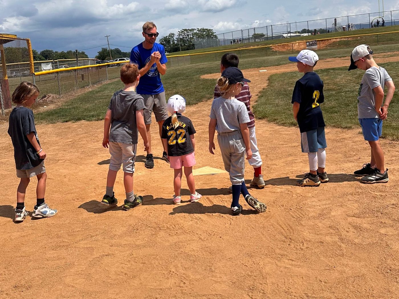 Coach Mark leading a group of kids at home plate