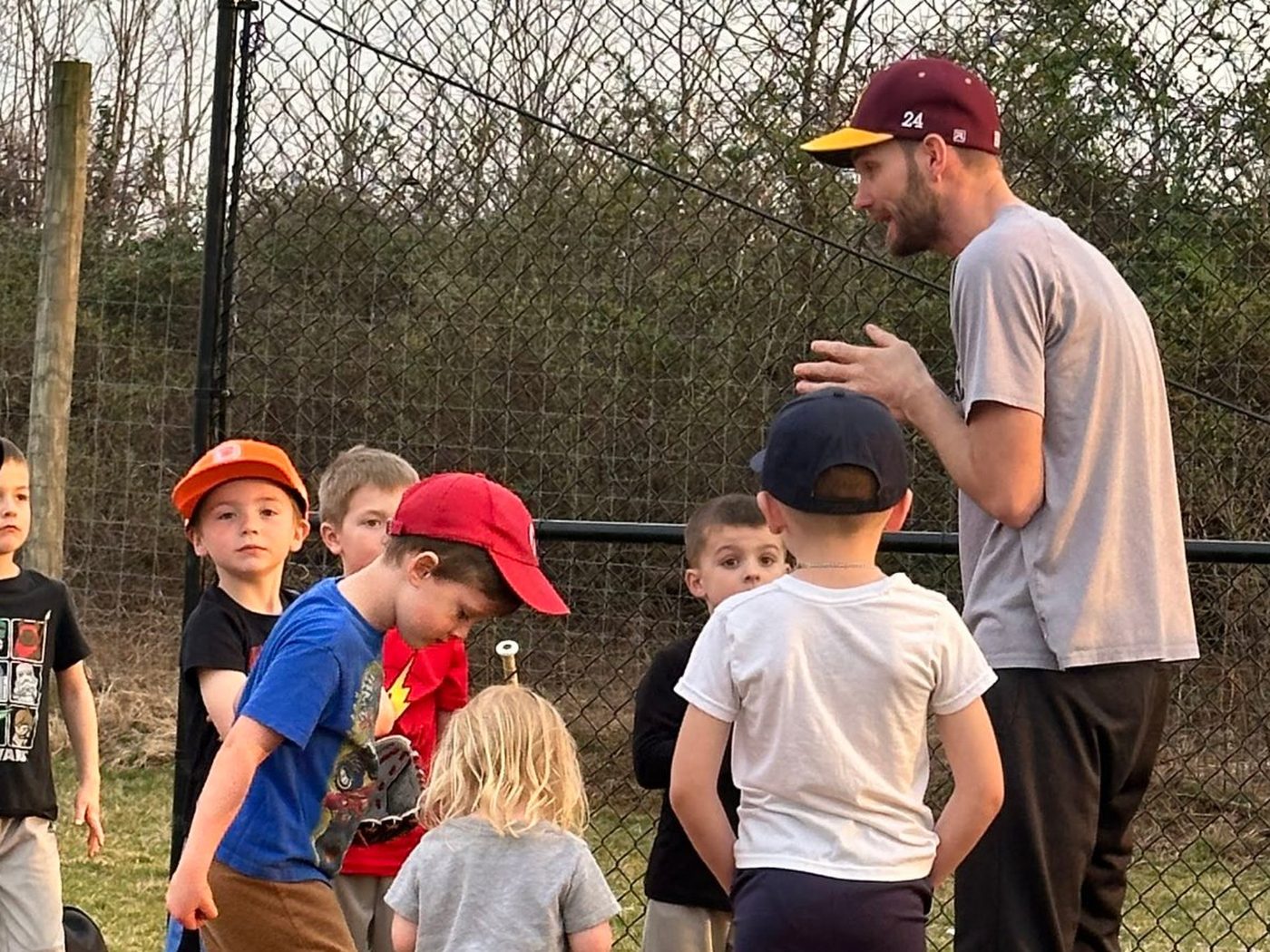 Coach Mark talking with a small group of young players at the field